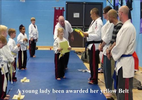Juniors a young lady being award her yellow belt
